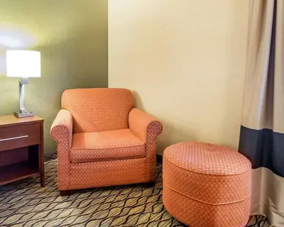 a room with an orange chair and a stool at Comfort Inn Winchester in Winchester