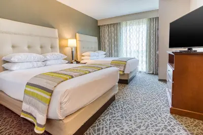 a hotel room with two beds and a flat screen tv at Drury Inn & Suites Cincinnati Northeast Mason in Mason