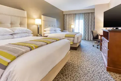 a hotel room with two beds and a flat screen tv at Drury Inn & Suites Cincinnati Northeast Mason in Mason
