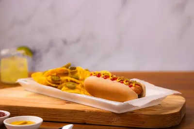 a hot dog and chips on a plate on a table at Drury Inn & Suites Cincinnati Northeast Mason in Mason