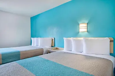 two beds in a room with blue walls at Motel 6 - Georgetown, KY - Lexington North in Georgetown