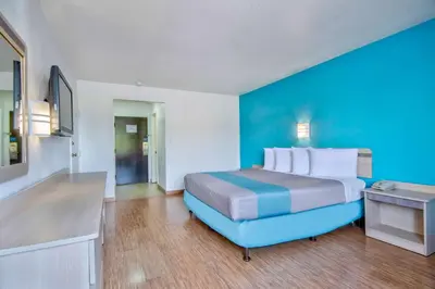 a hotel room with a bed and a blue wall at Motel 6 - Georgetown, KY - Lexington North in Georgetown