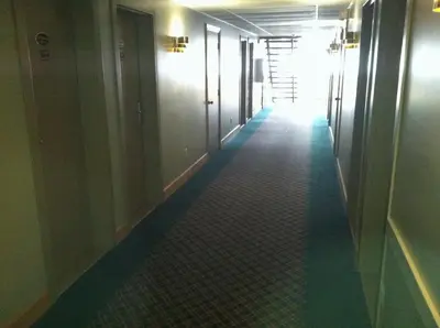a hallway with a long corridor with a long floor at Heritage Inn Mansfield in Mansfield