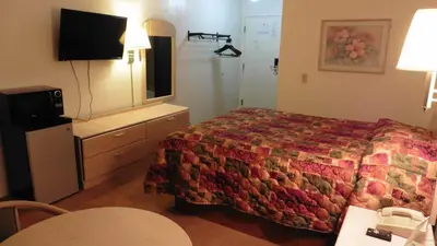 a hotel room with a bed and a television at Heritage Inn Mansfield in Mansfield
