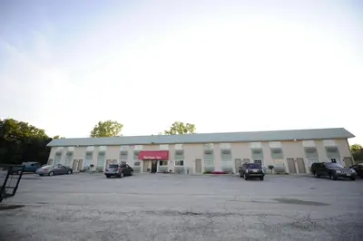 a large building with cars parked in a parking lot at Heritage Inn Mansfield in Mansfield