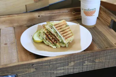 a sandwich on a plate with a pickle and a drink at The Westin Cincinnati in Cincinnati