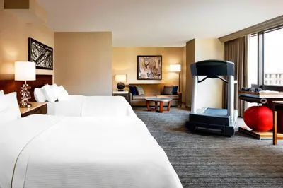 a hotel room with two beds and a fireplace at The Westin Cincinnati in Cincinnati