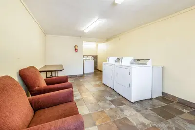 a room with a couch and a table and a kitchen at Motel 6-Mansfield, OH in Mansfield
