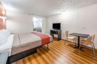 a hotel room with a bed and a desk and a table at Motel 6-Mansfield, OH in Mansfield