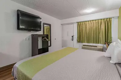 a bedroom with a large bed with a flat screen tv at Days Inn by Wyndham Cincinnati I-71 in Cincinnati