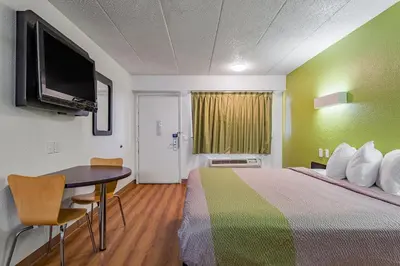 a hotel room with a bed and a table and a television at Days Inn by Wyndham Cincinnati I-71 in Cincinnati