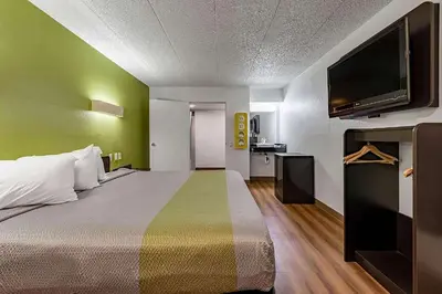 a hotel room with a bed and a flat screen tv at Days Inn by Wyndham Cincinnati I-71 in Cincinnati
