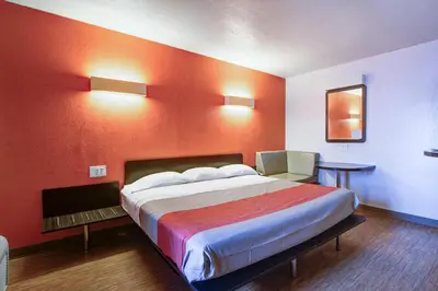 a hotel room with a large bed and a chair at Motel 6-Richfield, OH in Richfield