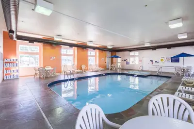 a large pool in a room with chairs and tables at Motel 6-Huron, OH - Sandusky in Huron