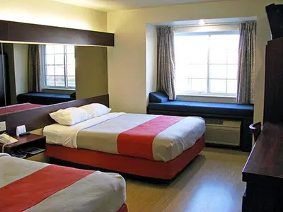 a hotel room with two beds and a chair at Motel 6-Huron, OH - Sandusky in Huron