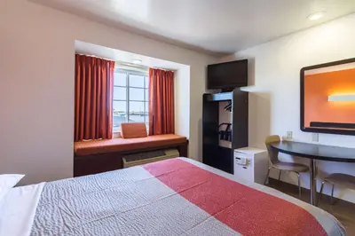 a hotel room with a bed and a desk and a window at Motel 6-Huron, OH - Sandusky in Huron