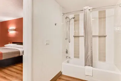 a bathroom with a shower and a tub and a bed at Motel 6-Youngstown, OH in Youngstown
