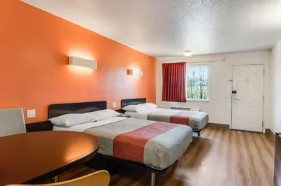 a hotel room with two beds and a table at Motel 6-Youngstown, OH in Youngstown
