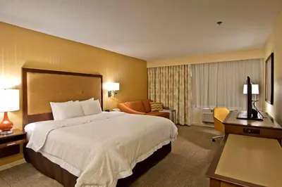 a hotel room with a large bed and a chair at Hampton Inn & Suites Chillicothe in Chillicothe