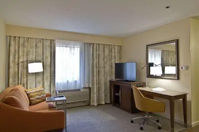 a hotel room with a couch and a desk and a mirror at Hampton Inn & Suites Chillicothe in Chillicothe