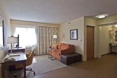 a living room with a couch and a desk in a hotel room at Hampton Inn & Suites Chillicothe in Chillicothe