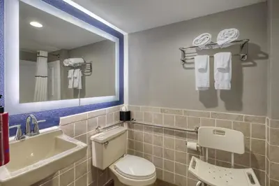 a bathroom with a toilet and a sink and a mirror at SureStay by Best Western Greenville in Greenville