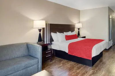 a hotel room with a bed and a couch at SureStay by Best Western Greenville in Greenville
