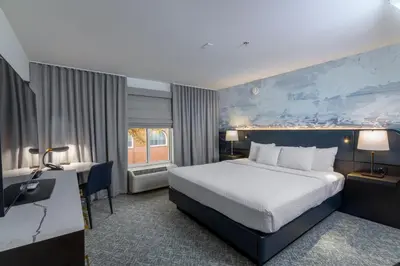 a hotel room with a bed and a desk at The Ohioan Hotel and Event Center in Lewis Center