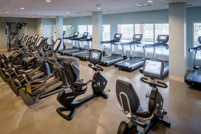 a gym with rows of treadmills and elliptical machines at The Ohioan Hotel and Event Center in Lewis Center
