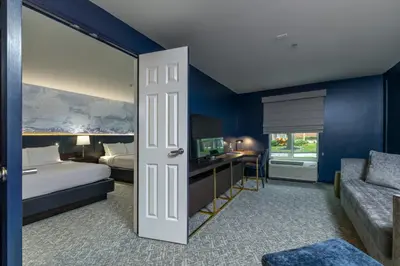 a hotel room with a bed and a desk and a bedroom at The Ohioan Hotel and Event Center in Lewis Center