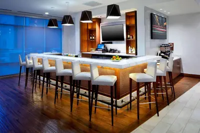 a kitchen with a bar with white stools at SpringHill Suites by Marriott Columbus Easton Area in Columbus