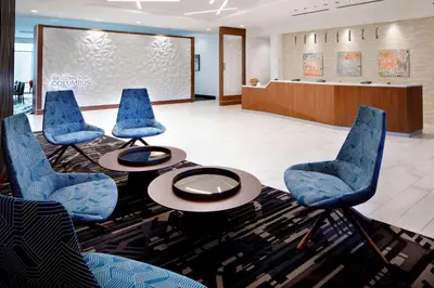 a lobby with blue chairs and a table and a waiting room at SpringHill Suites by Marriott Columbus Easton Area in Columbus