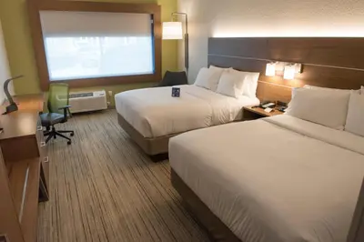 a hotel room with two beds and a desk at Holiday Inn Express & Suites - Dayton Southwest by IHG in Dayton