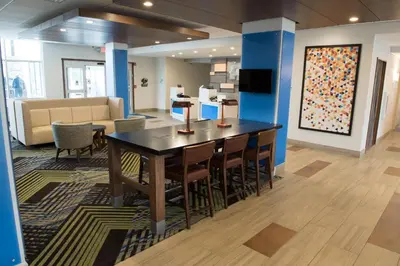 a conference room with a table and chairs and a couch at Holiday Inn Express & Suites - Dayton Southwest by IHG in Dayton