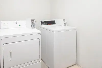 a white laundry room with a washer and dryer at Skylight Inn Willoughby - Cleveland Mentor in Willoughby