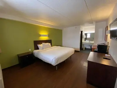 a hotel room with a bed and a desk and a room at Skylight Inn Willoughby - Cleveland Mentor in Willoughby