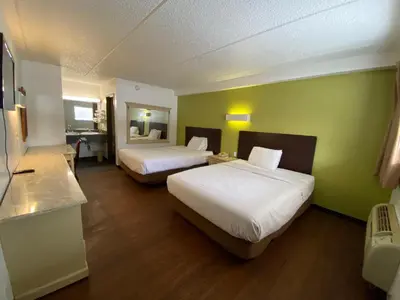 a hotel room with two beds and a bathroom at Skylight Inn Willoughby - Cleveland Mentor in Willoughby