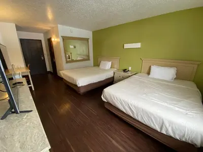 a hotel room with two beds and a mirror at Skylight Inn Willoughby - Cleveland Mentor in Willoughby