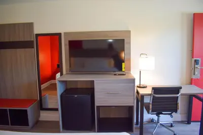 a room with a desk with a tv on a desk sidx sidx sidx at Ramada by Wyndham Cleveland Airport West in Fairview Park