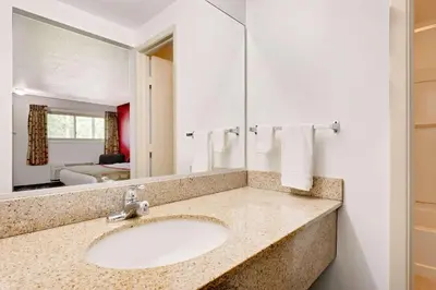 a bathroom with a sink and a mirror at Ramada by Wyndham Cleveland Airport West in Fairview Park