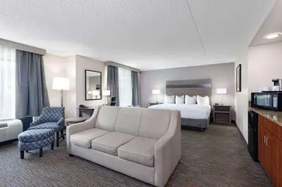 a hotel room with a bed and a couch at Wingate by Wyndham Lima in Lima