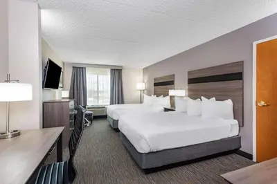 a hotel room with two beds and a desk at Wingate by Wyndham Lima in Lima