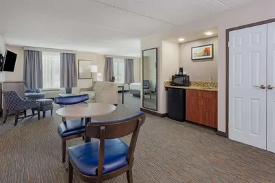 a hotel room with a table and chairs and a living room at Wingate by Wyndham Lima in Lima