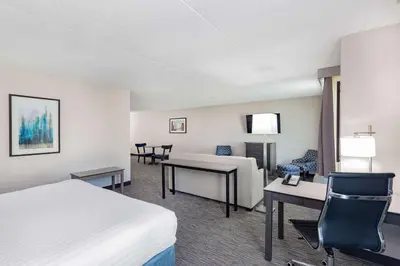 a hotel room with two beds and a desk at Wingate by Wyndham Lima in Lima