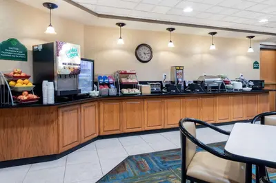 a food counter in a restaurant with a clock on the wall at Wingate by Wyndham Lima in Lima