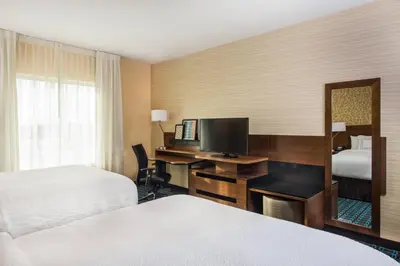 a hotel room with two beds and a desk with a television at Fairfield by Marriott Inn & Suites Dayton Downtown in Dayton