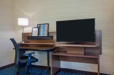 a desk with a monitor and a chair in a hotel room at Fairfield by Marriott Inn & Suites Dayton Downtown in Dayton