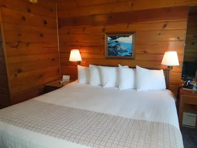 a bedroom with a white bed with wooden walls at Arlington Inn in Port Clinton