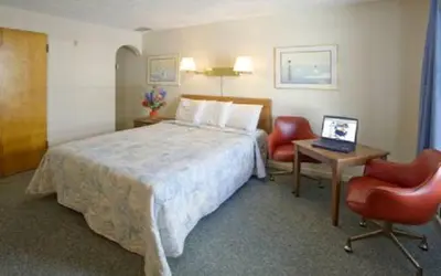 a hotel room with a bed and a desk with a laptop at Arlington Inn in Port Clinton