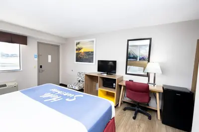 a hotel room with a bed and a desk and a computer at Days Inn by Wyndham Dayton Huber Heights Northeast in Huber Heights